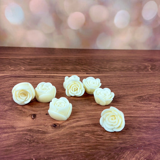 3D rose-shaped wax melts on a wooden surface with a blurred light background